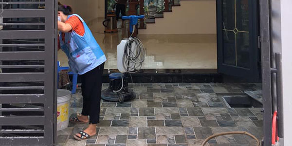 Nhân viên dịch vụ vệ sinh sau xây dựng đang vệ sinh cửa, khung cửa nhà mới xây xong